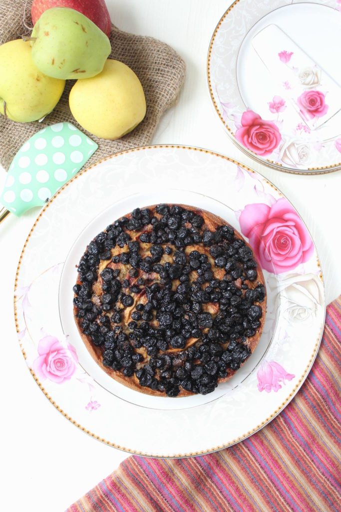 Cake topped with Apple wedges and frozen blackberries