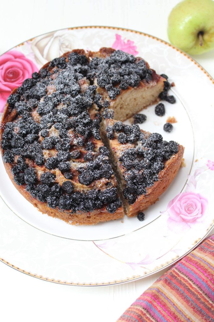 Fall cake topped with apple wedges and blackberries